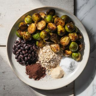 In the same bowl stir together the remaining ingredients until a paste forms. Transfer roasted Brussels sprouts to bowl; toss well to coat evenly. Return sprouts to baking pan, spreading evenly. Roast 15 minutes more. Serve immediately.